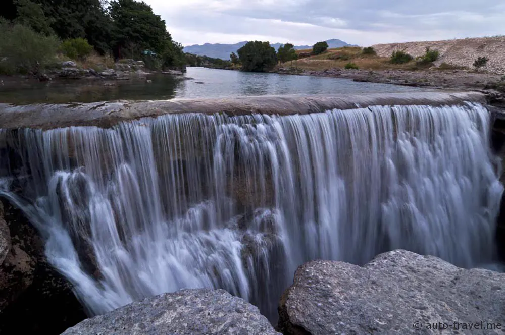 Water returning over a broad rocky waterfall